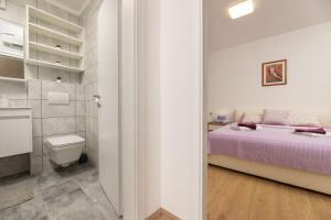 a small bedroom with a bed and a toilet at Apartments Danica by EL-PI TOURS in Njivice +34 photos