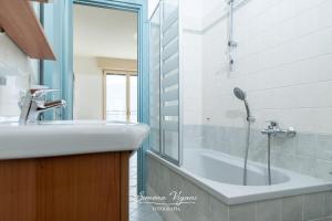 Un baño con bañera, lavabo y ducha. en Casa Jimmy, en Lovere 25 fotos más