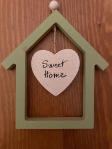 un signe en forme de cœur sur un mur avec les mots "maison douce" dans l'établissement sweet home, à Soianella