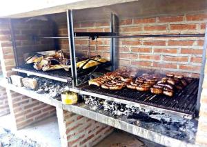 a grill with meat and other food on it at EL ESTABLO - Casa de Campo Vacacional con pileta privada - Jujuy in San Salvador de Jujuy