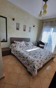 a bedroom with a bed with a floral bedspread at Lovely Apartment in CABO, RIVIERA BEACH in Cabo Negro