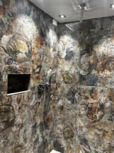 La salle de bains est pourvue d'un mur en pierre et d'une douche. dans l'établissement La Residenza Isabella, à Milan