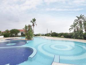 a swimming pool with blue water and palm trees at Nice residence in San Nicol di Ricadi with pool in Ricadi
