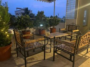 eine Terrasse mit einem Tisch, Stühlen und Topfpflanzen in der Unterkunft Myra's house in Kolhapur