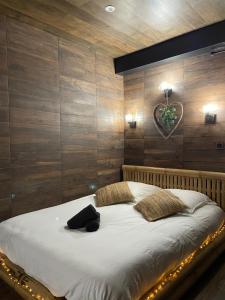 ボアシー・サン・レジェにあるBY NEPTUNE - Appartement Indonésienの木製の壁のベッドルーム1室(大型ベッド1台付)