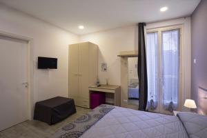 a bedroom with a bed and a desk and a window at Ventitrémarzo Guest House in Novara