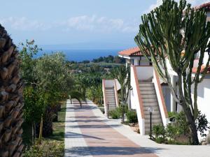 a pathway leading to a villa with a view of the ocean at Nice residence in San Nicol di Ricadi with pool in Ricadi