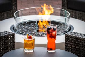 two cocktails on a table in front of a fire pit at Marriott Boston Quincy in Quincy