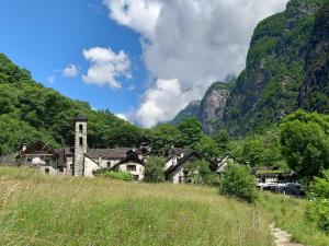 an old village in the mountains with a church at Casa Coerente Cavergno - Room 1 in Cevio +13 photos