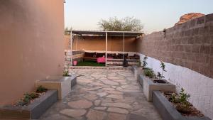 a patio with a stone walkway with a wall at استراحات يمك دروبي in Madain Saleh