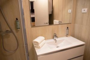 bagno con lavandino e doccia con specchio di Dea Del Mar Apartments a Izola