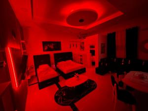 une chambre rouge avec un canapé et une table. dans l'établissement ESTO's Apartament near Tirana Airport 1 - Self CheckIN -Netflix - FREE Parking, à Valjiosi