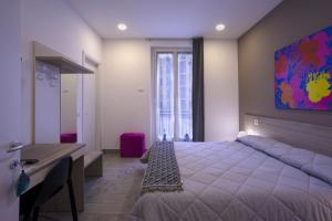 um quarto com uma cama, uma secretária e uma janela em Ventitrémarzo Guest House em Novara