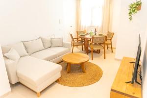 Una sala de estar con un sofá blanco y una mesa. en Casa Los Lances | Reformado Junto a la Playa, en Tarifa