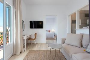 a white living room with a couch and a table at Reana Elegant Apartments in Barbati