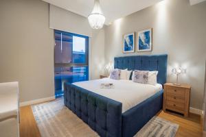 een bed met een blauw hoofdeinde in een slaapkamer bij Nasma Luxury Stays - City Walk Building 5 in Dubai +116 foto's