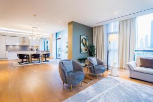 een woonkamer met een bank, een tafel en stoelen bij Nasma Luxury Stays - City Walk Building 5 in Dubai