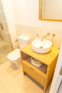 a bathroom with a sink and a toilet at Casa Los Lances Deluxe - Reformado Junto a la Playa y Terraza in Tarifa