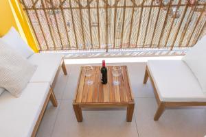 a table with glasses and a bottle of wine on it at Casa Los Lances Deluxe - Reformado Junto a la Playa y Terraza in Tarifa
