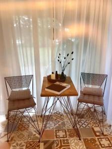 uma mesa e duas cadeiras num quarto com cortinas brancas em Your Private Retreat Island em Priedkalne