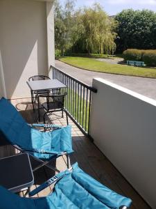 een balkon met 2 stoelen en een tafel en een tafel bij Bel appartement proche mer avec terrasse in Roscoff