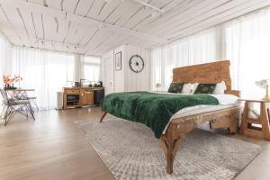 Your Private Retreat Island في Priedkalne: غرفة نوم بسرير كبير مع بطانية خضراء