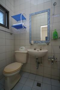 a bathroom with a toilet and a sink and a mirror at Sunrise B&B in Huxi +35 photos