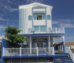 a blue and white building with a balcony at Sunrise B&B in Huxi