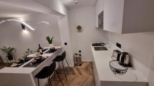 una cocina blanca con encimera y taburetes en BEAUTIFUL APARTMENT,AMAZING VIEW,parking! en Dubrovnik
