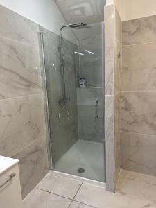 y baño con ducha y puerta de cristal. en Appartement du Thiers en Niza