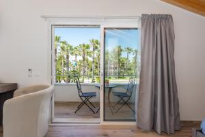 een woonkamer met een glazen schuifdeur met een tafel en stoelen bij Affittacamere Mare nel Cuore in Torre Grande