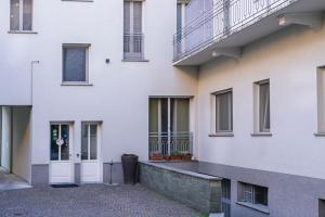 un edificio blanco con una puerta y ventanas blancas en Ventitrémarzo Guest House, en Novara