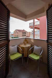 balcón con mesa, sillas y vistas en Apartments Villa Nataly, en Zadar