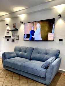 uma sala de estar com um sofá e uma televisão de ecrã plano em Casa Siculi em Taormina
