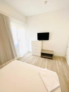 a bedroom with a bed and a flat screen tv at Apartamentos Hotel Puente de Hierro in Benicàssim