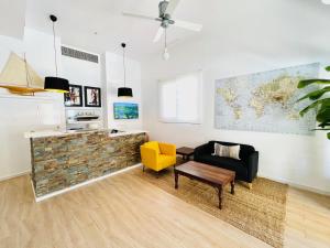 sala de estar con sofá y silla amarilla en Apartamentos Hotel Puente de Hierro, en Benicàssim