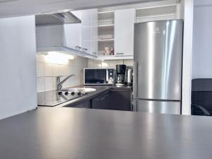 Il comprend une grande cuisine équipée d'un réfrigérateur en acier inoxydable. dans l'établissement Lovely Central Apartment Helsinki, à Helsinki