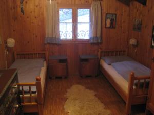 a bedroom with two beds and a window at Haus Belluti Graun in Cortaccia