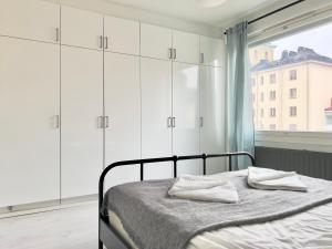 - une chambre avec un lit avec des placards blancs et une fenêtre dans l'établissement Lovely Central Apartment Helsinki, à Helsinki