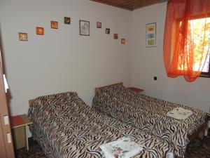 a bedroom with a zebra print bed and a window at Domek letniskowy nad jeziorem Dadaj na Mazurach in Biskupiec