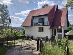 uma casa com um telhado de metal e uma cerca em Nowa Jutrzenka em Stryszawa