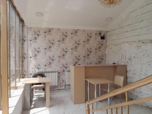a room with two tables and a wall with flowers at Hotelvvv888 in Yerevan