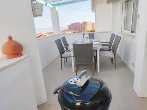una sala da pranzo con tavolo, sedie e finestra di ATICO con vistas al mar a 100 metros de la playa a Torre de Benagalbón