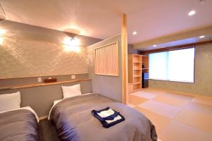 - une chambre avec 2 lits et une grande fenêtre dans l'établissement こんぴら温泉 貸切湯の宿 ことね, à Kotohira