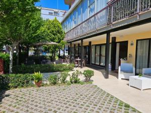 un patio de un edificio con sillas y árboles en Hotel Paradiso en Rímini