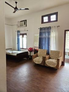 a living room with a bed and a couch and chairs at Bhaskar Homestay in Dibrugarh