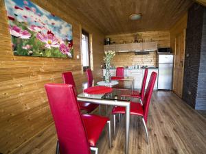 a dining room with a table and red chairs at Sea view holiday home in Mielno with balcony in Mielno