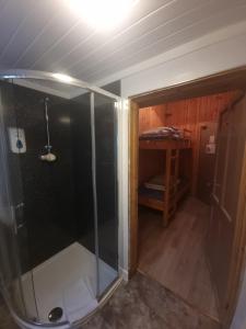 a shower with a glass door in a room at Blackwater Hostel in Kinlochleven