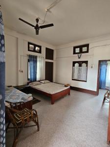 - une chambre avec un lit et un ventilateur de plafond dans l'établissement Bhaskar Homestay, à Dibrugarh