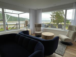 a living room with a couch and two chairs and a table at Domaine Belle Plage in Baie-Saint-Paul